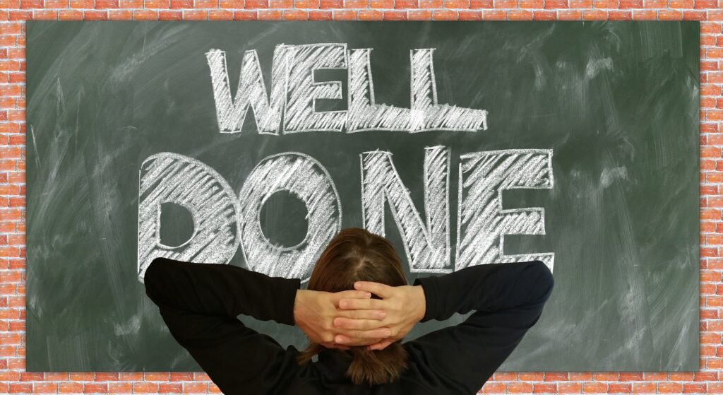 Person Relaxing in front of Chalk board that says well done